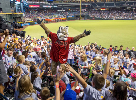 The Diamondbacks mascot stands in a crowd of children in the stands
