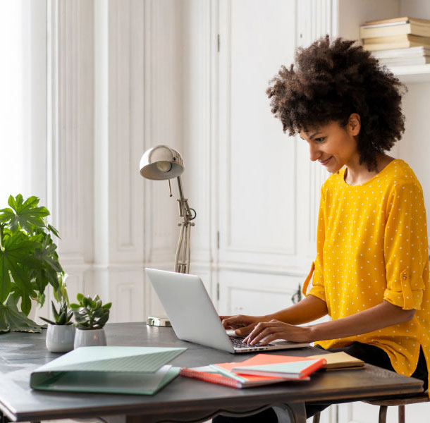 Mujer sentada en un escritorio usando una computadora