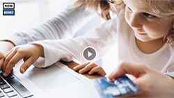 How to teach your kids about money—without cash mom with little girl on laptop with credit card in hand
