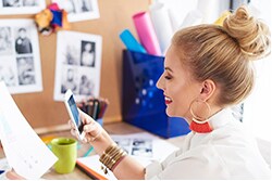 10 Digital Marketing Tips for Small Business Owners woman looking at smartphone and paper