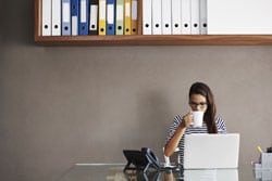 10 Digital Marketing Tips for Small Business Owners woman at desk with laptop in front and sipping coffee from mug