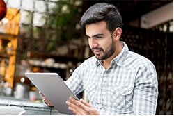 Go Live! Three ways to attract customers with a Facebook Live video campaign man looking at tablet