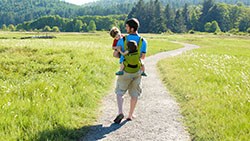 5 Estrategias simples para aumentar tus ahorros padre y niños caminando en el parque