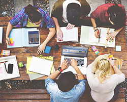 You aren't setting goals and working toward them. Group of people workimg together on a table.