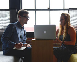 You aren't recognizing your employees. Man and woman talking in the front of open laptop.