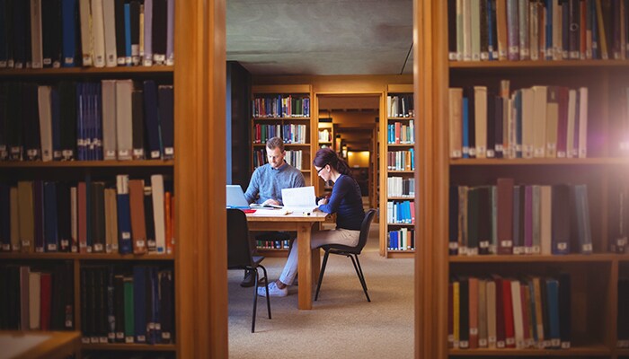 How to save money on college textbooks man & woman studying in library