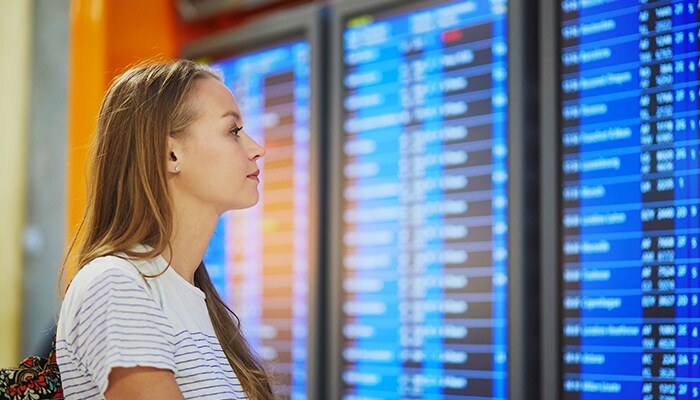GOOD story woman looking at flight schedule on screen