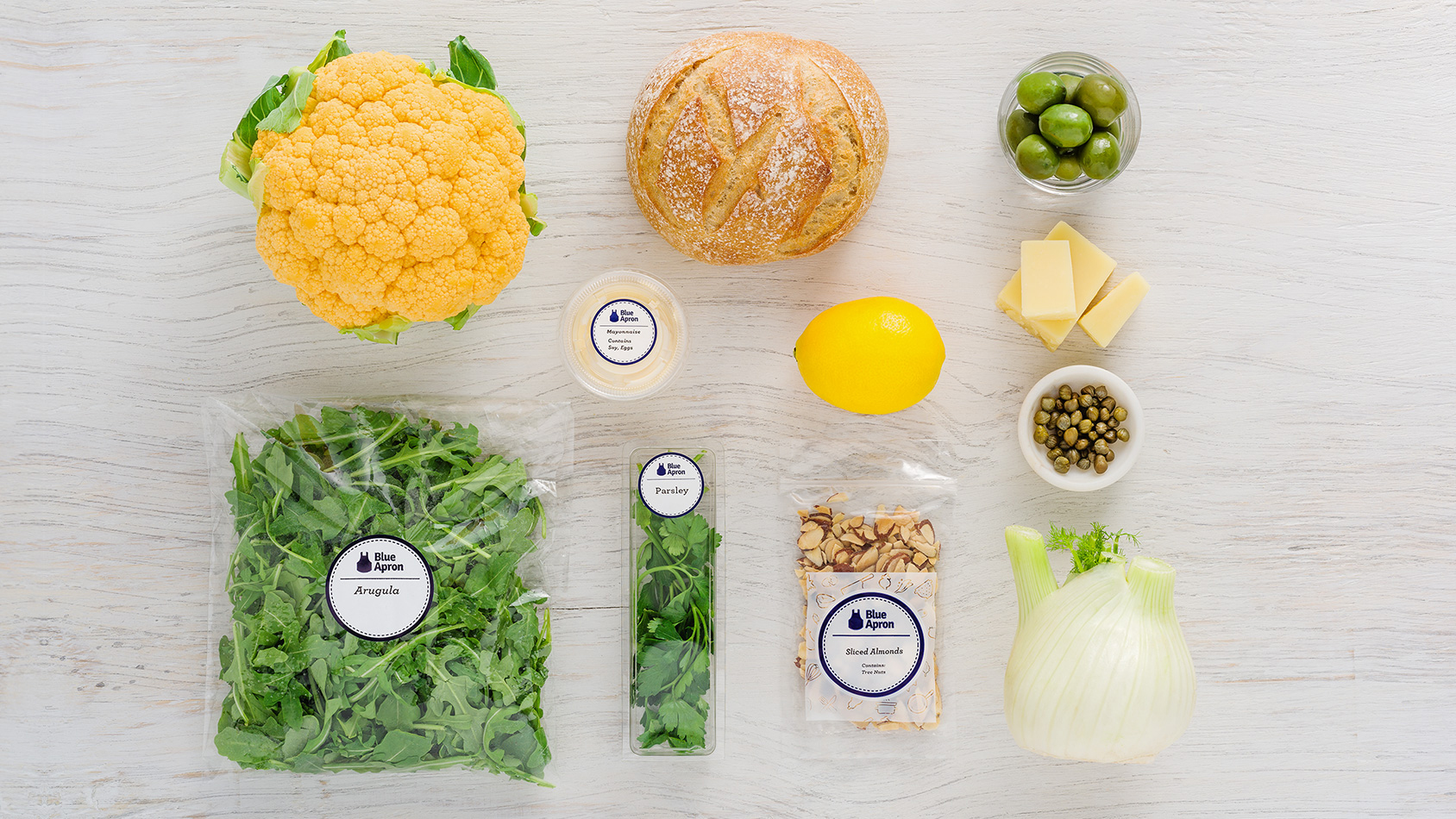 Blue Apron Vegetables, bread, cheese and nuts on table