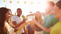Throw a Summer Party Group of people having drinks in backyard