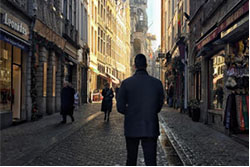 The art of getting paid - while getting away man standing on cobblestone street