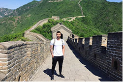 The art of getting paid - while getting away man standing on top of the great China Wall