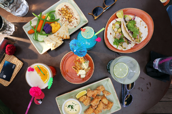 NYC Travel Guide food plates and drinks on table along with Chase Sapphire card