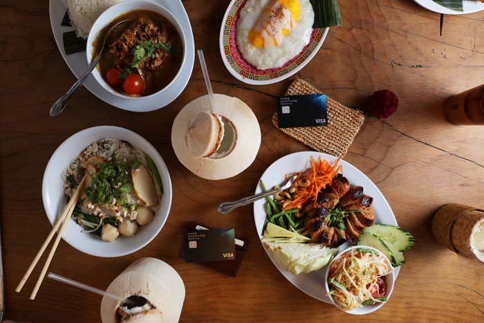 LA Travel Guide food plates and fresh open coconut water on table along with Chase Sapphire cards
