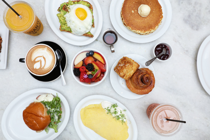 LA Travel Guide breakfast food with fruits and pastry along with coffee and juice on table
