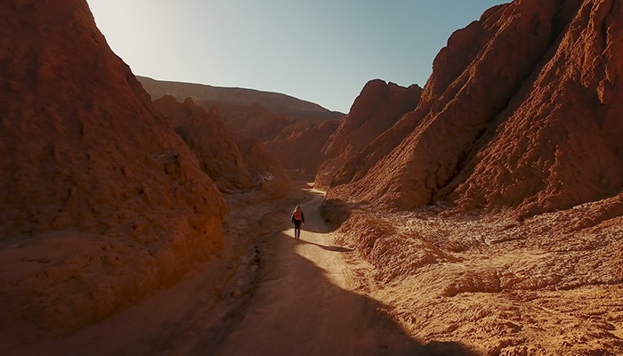 Sapphire Seven: Around the World Travel Guide Hiker on the road between a desert valley