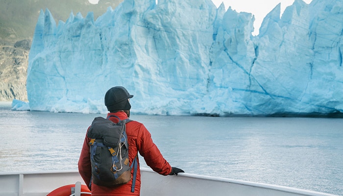 Sapphire Seven: Around the World Travel Guide Traveler on boat looking over glacial formation