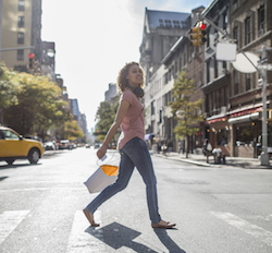 Local spending woman walking with shopping bag