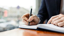 6 tips for crafting a winning business plan Closeup of man writing in a book