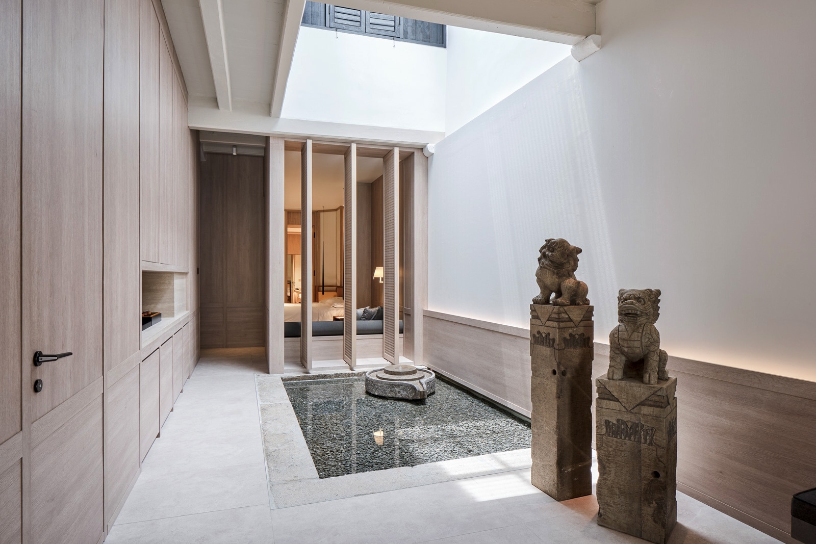 A sunny room with a skylight and ancient statues.