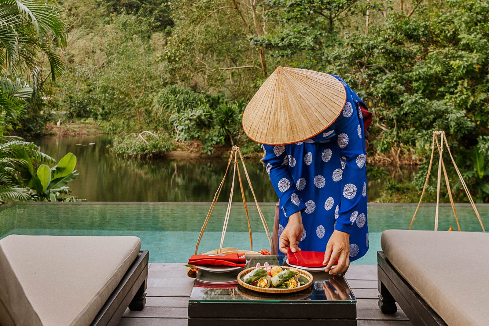 A person serves a meal on the terrace of the Lagoon Pool Villa at Banyan Tree Lang Co.