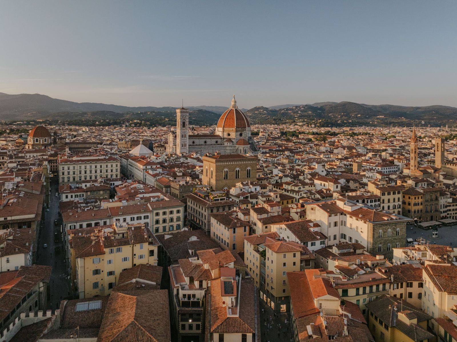 Panoramic view of Florence, Italy, highlighting the iconic red dome of the Florence Cathedral and surrounding buildings.