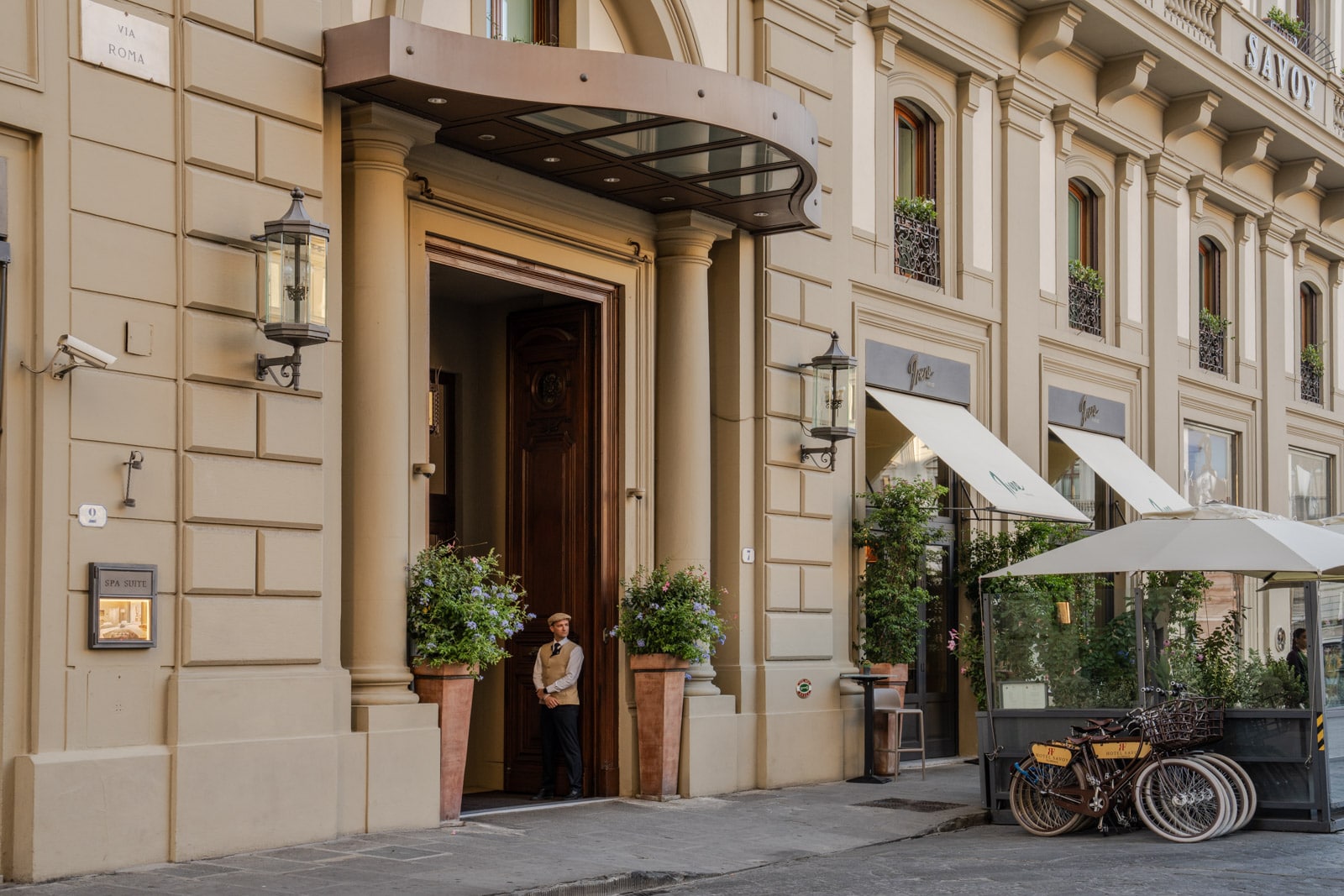 An attendant stands at the entrance of Hotel Savoy in Florence, Italy.