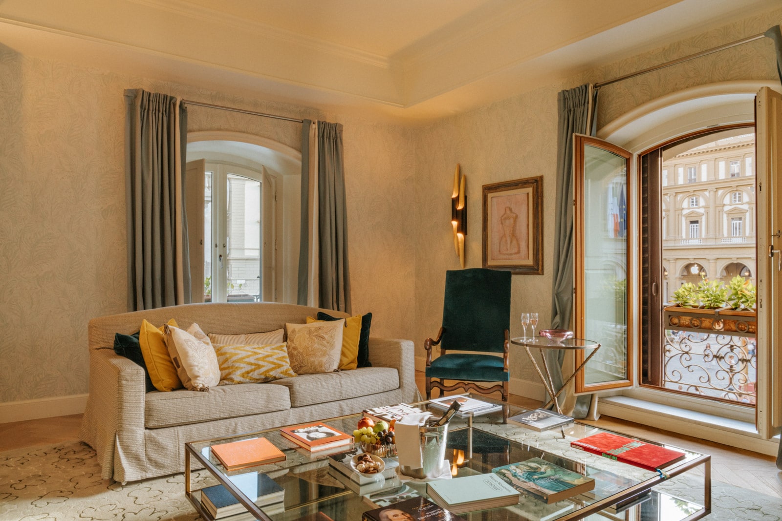 The living room of the Irene Artist Suite at Hotel Savoy in Florence boasts juliet balcony, sofa, and blackout curtains.