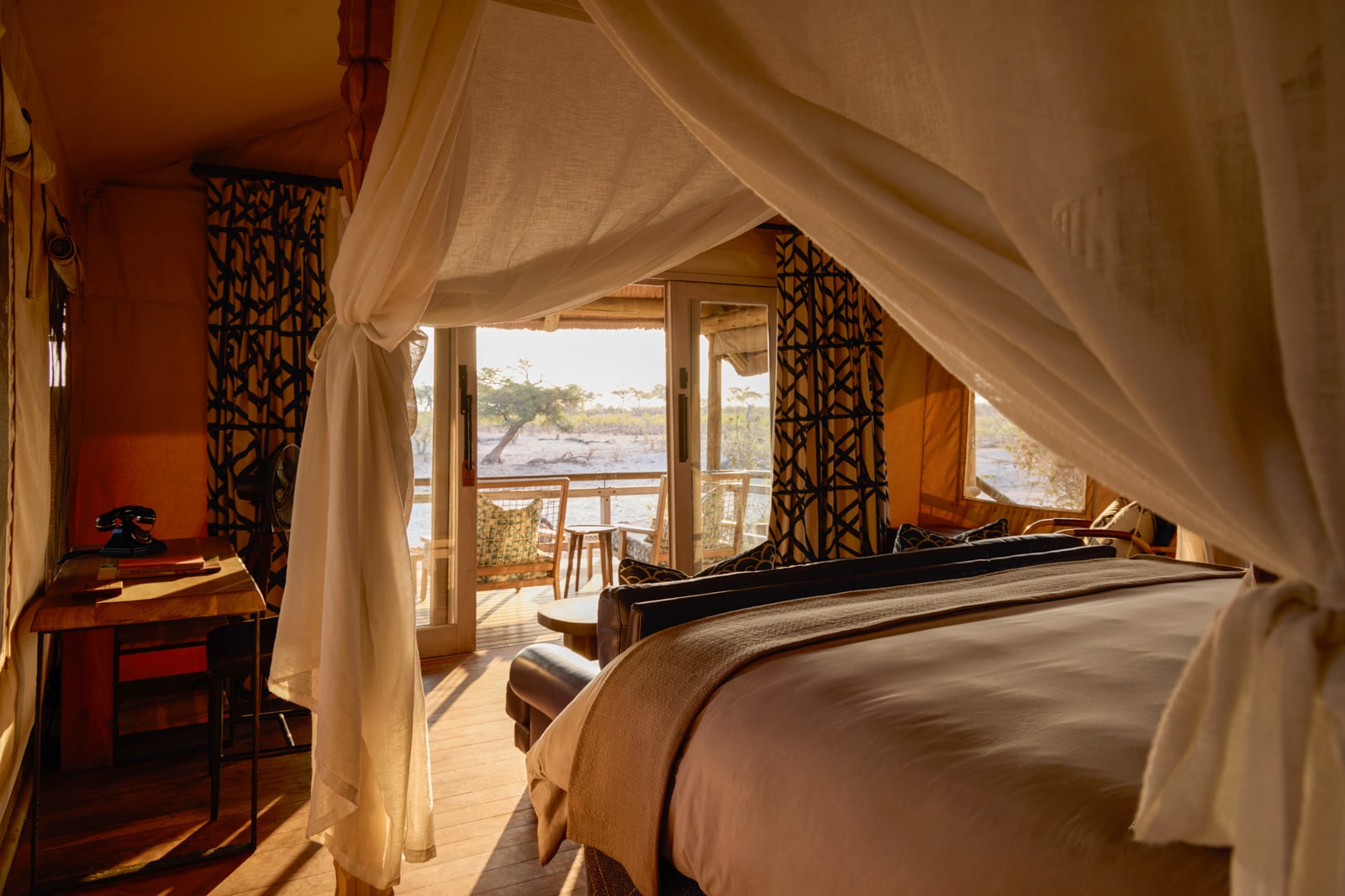 A bedroom with canopy bed and balcony.