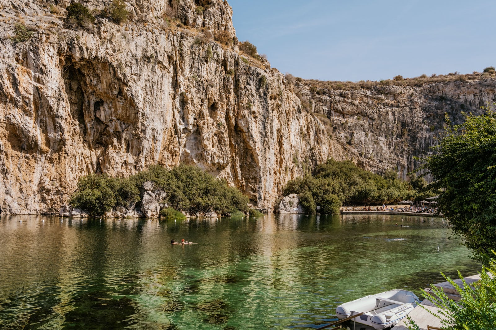 Cliffs line the shores of clear water at Lake Vouliagmeni near Athens, Greece.