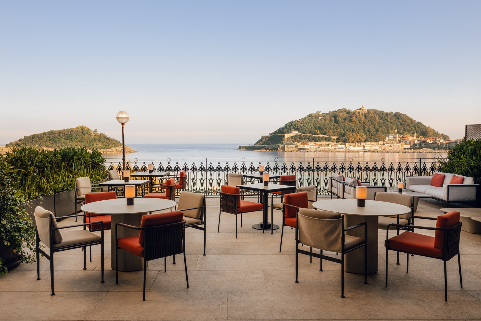 Restaurant seating on a terrace overlooking a bay.