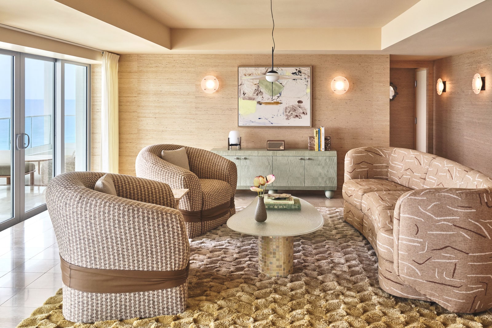 A hotel living area with coffee table, sofa and balcony.