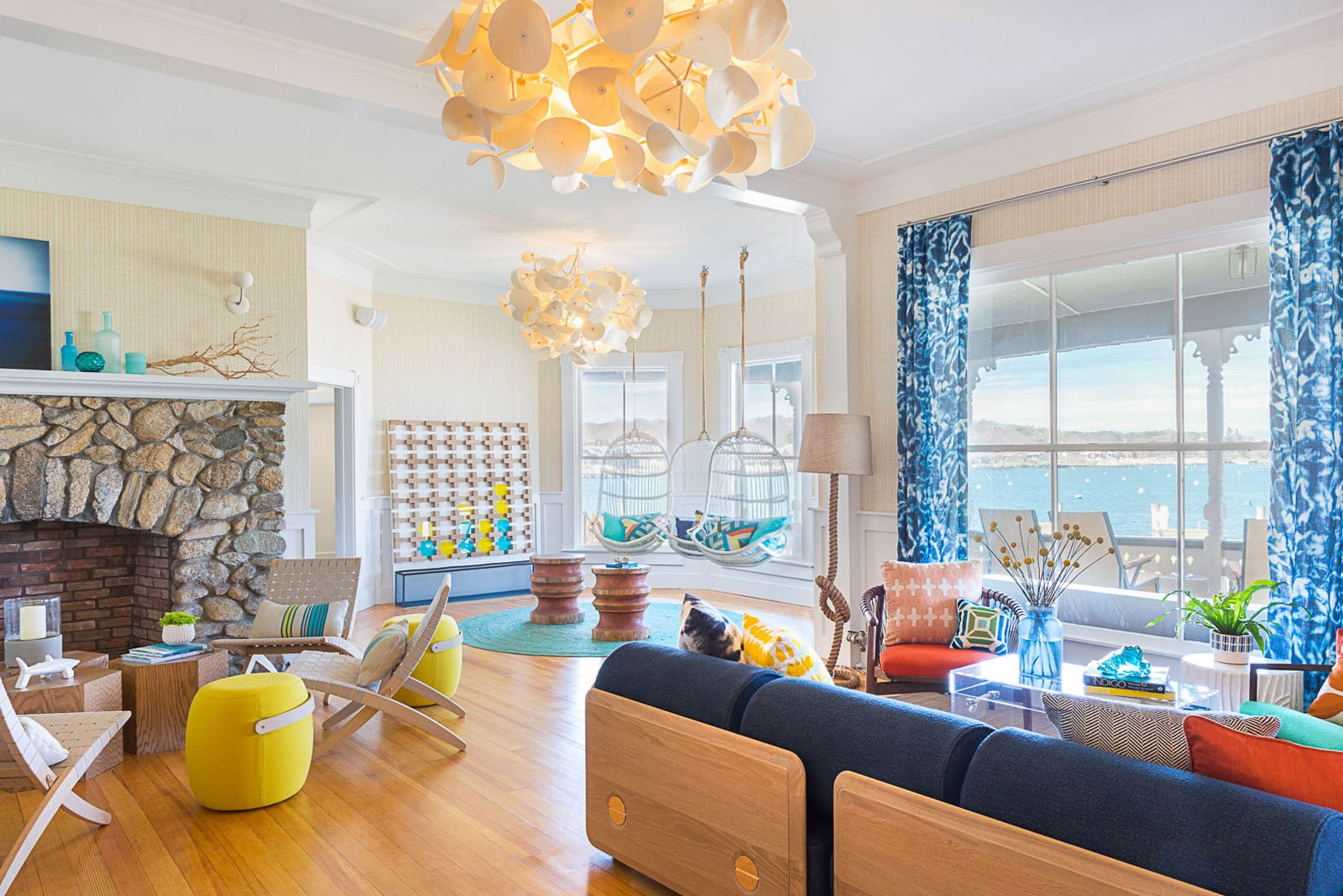 The lobby of a hotel features many modern seating options and large windows overlooking the ocean.