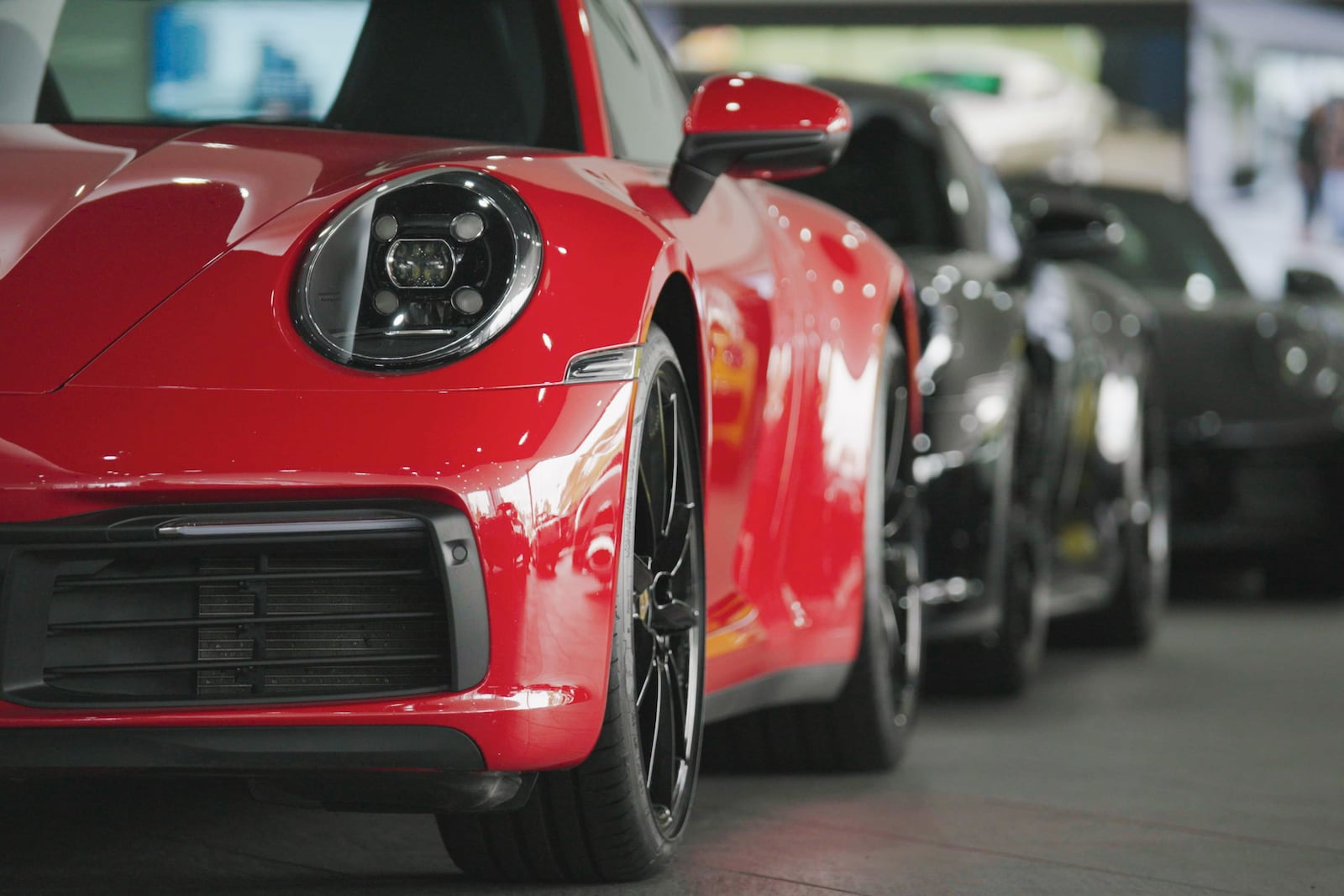 Several sports cars sit parked in a line.