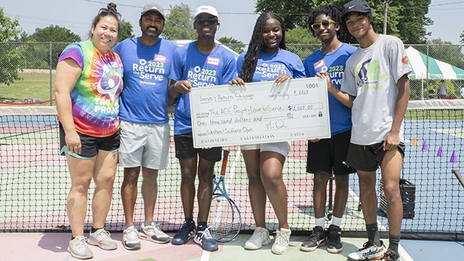 Group posing with a $1,000 check